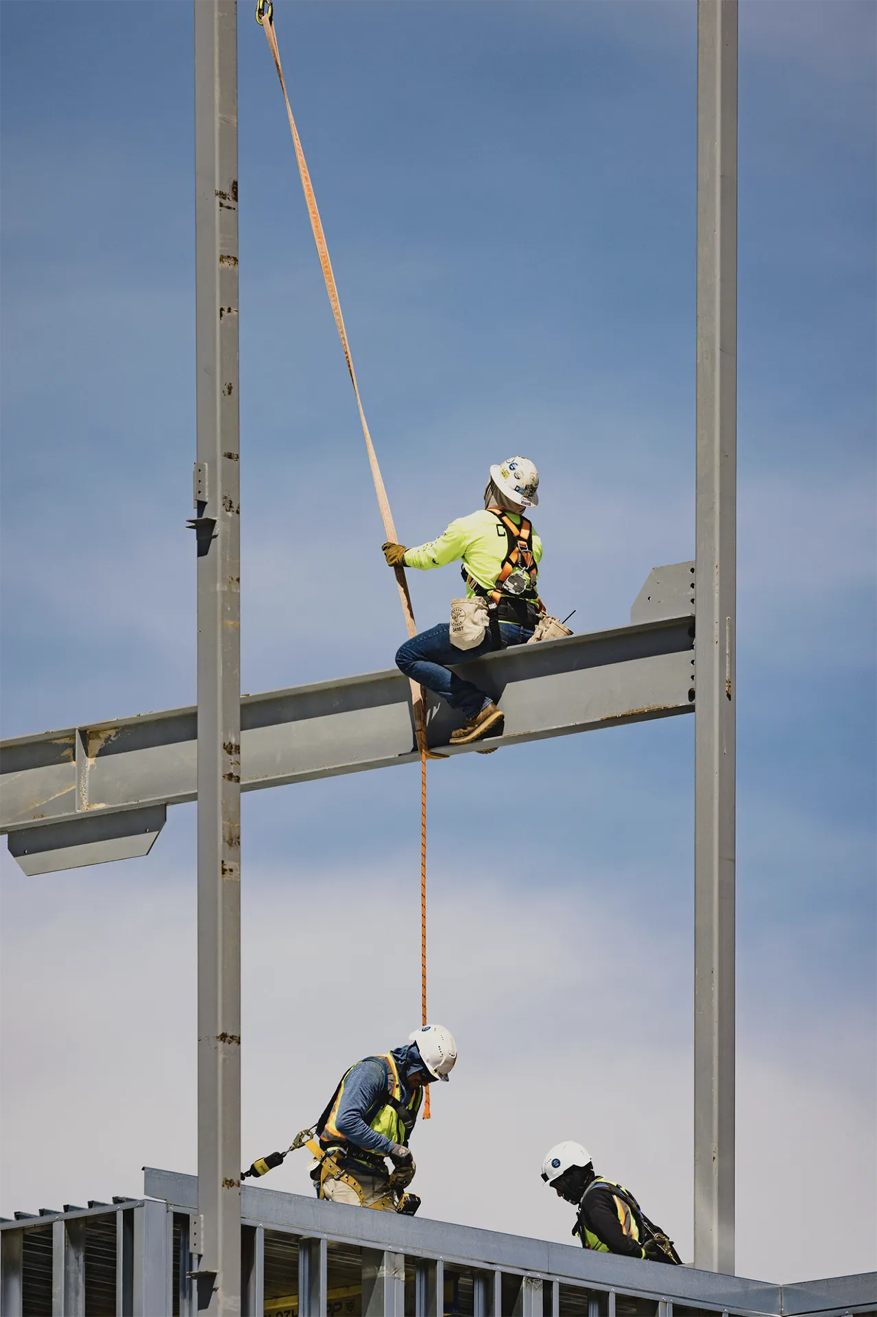 Construction crew working across structural steel girders